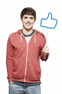 Teenage boy holding a social media sign smiling